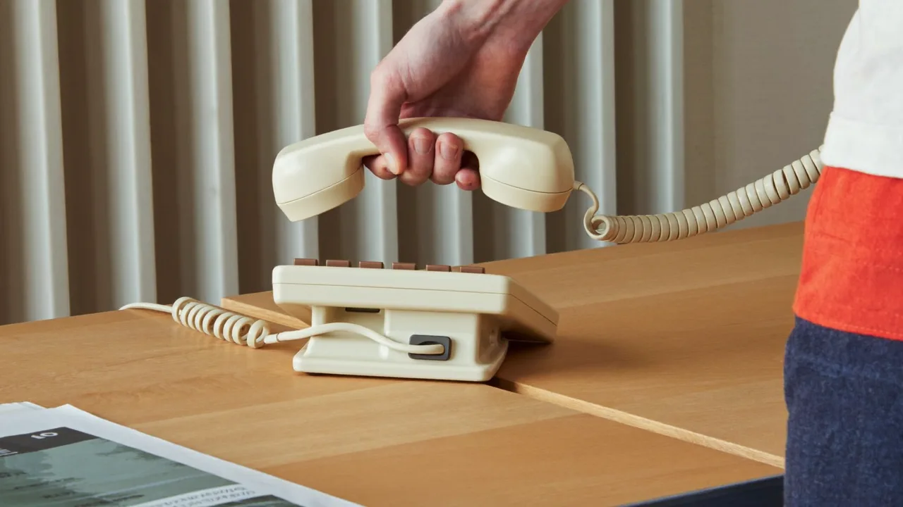 A hand lifting a telephone receiver to take responsibility for a callback.
