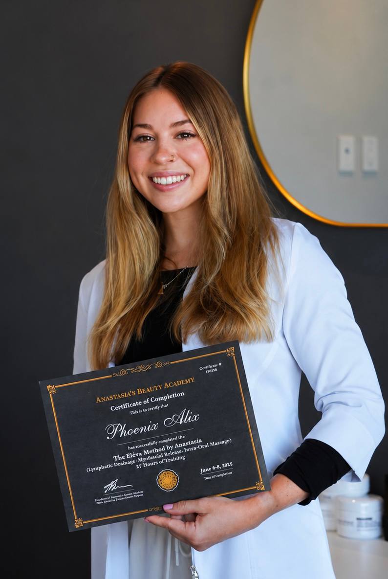 Phoenix Alix holding her facial massage training certificate